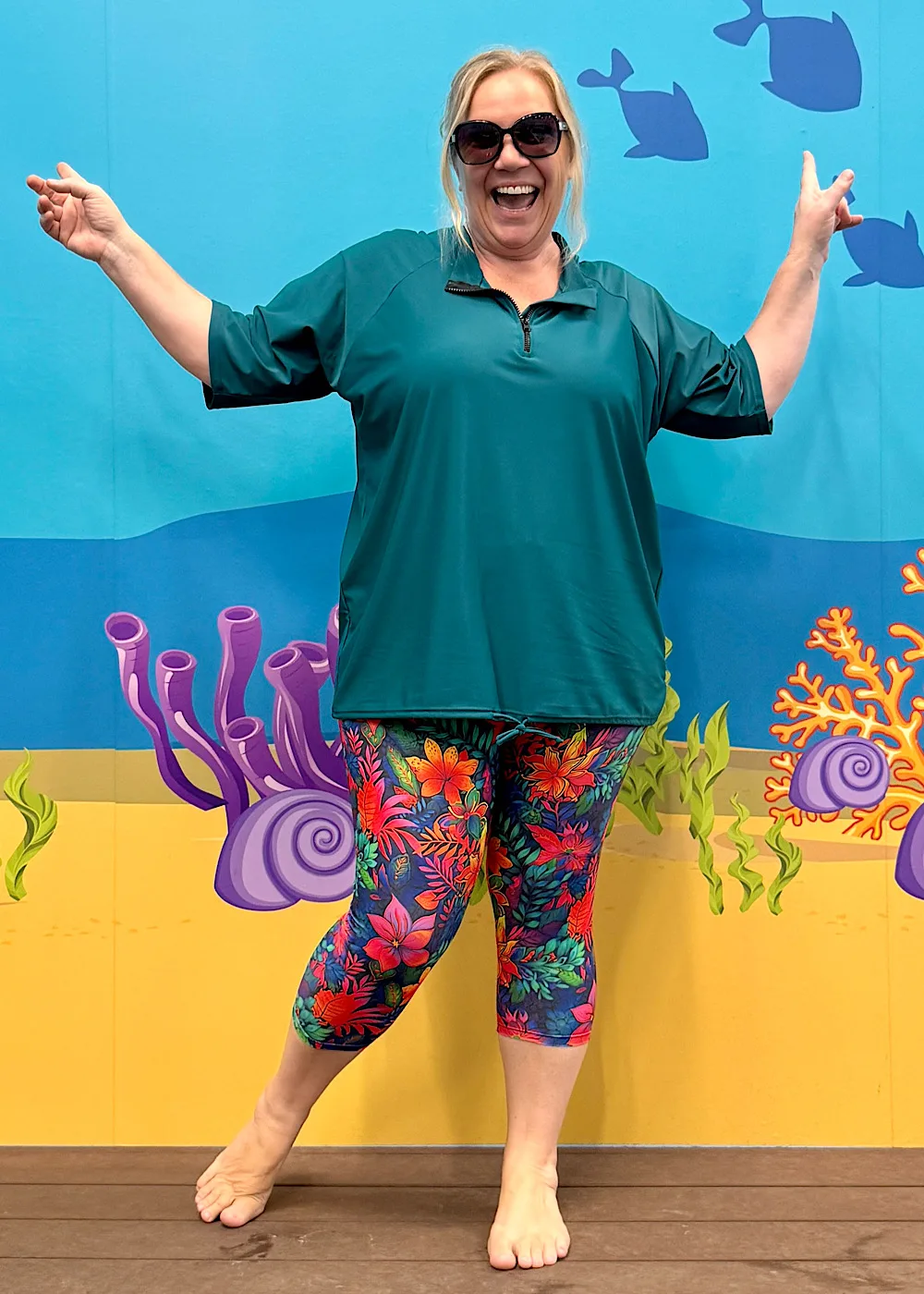 Plus size model wearing the trending Teal baggy rashie with short sleeves and neck zipper.