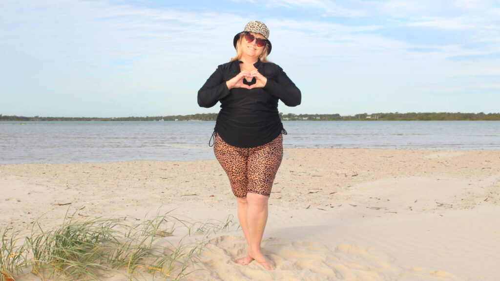 curvy lady wearing leopard print and making heart shape with hand