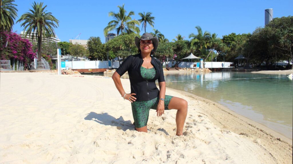 women wearing crocodile print swimsuit and black rash guard at beach