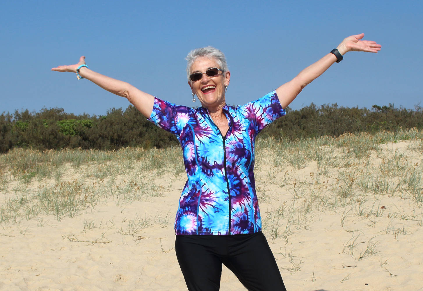 mature women on beach wearing tie dye rashie swim shirt