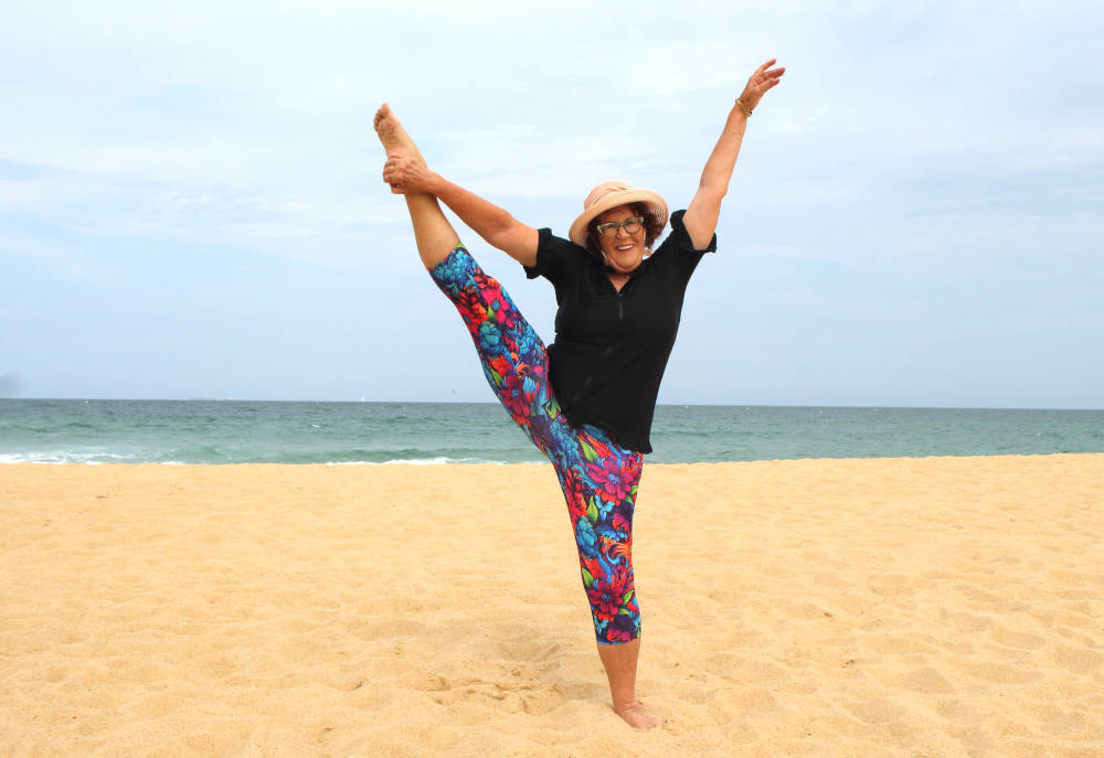 mature women performing gymnastics on sand dunes beach strong women supporting women age equality