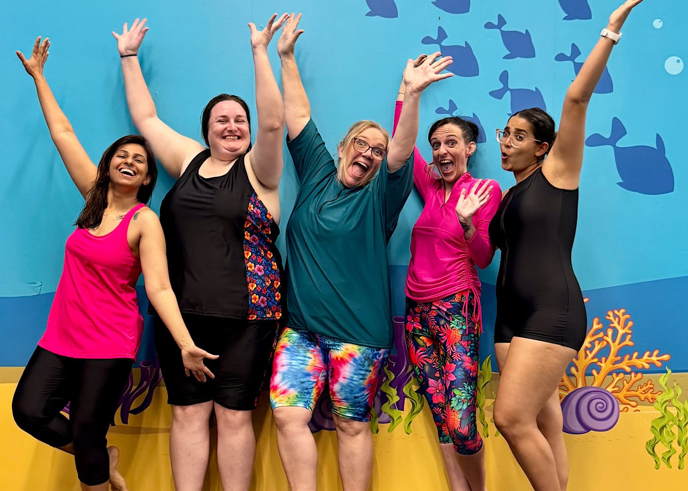 OceanRoad Swimwear founder smiling with Kara, Alysha, and mature learn-to-swim students poolside at JUMP! Richlands.