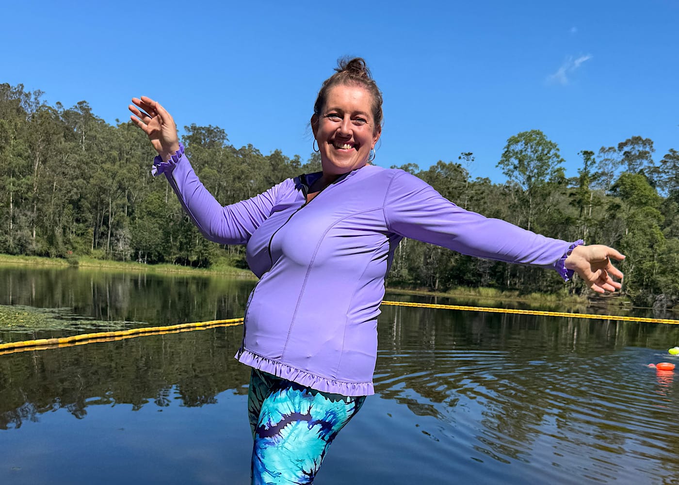 A candid close up of Laura Vincent laughing by the water in her Ocean Road Swimwear rashie.
