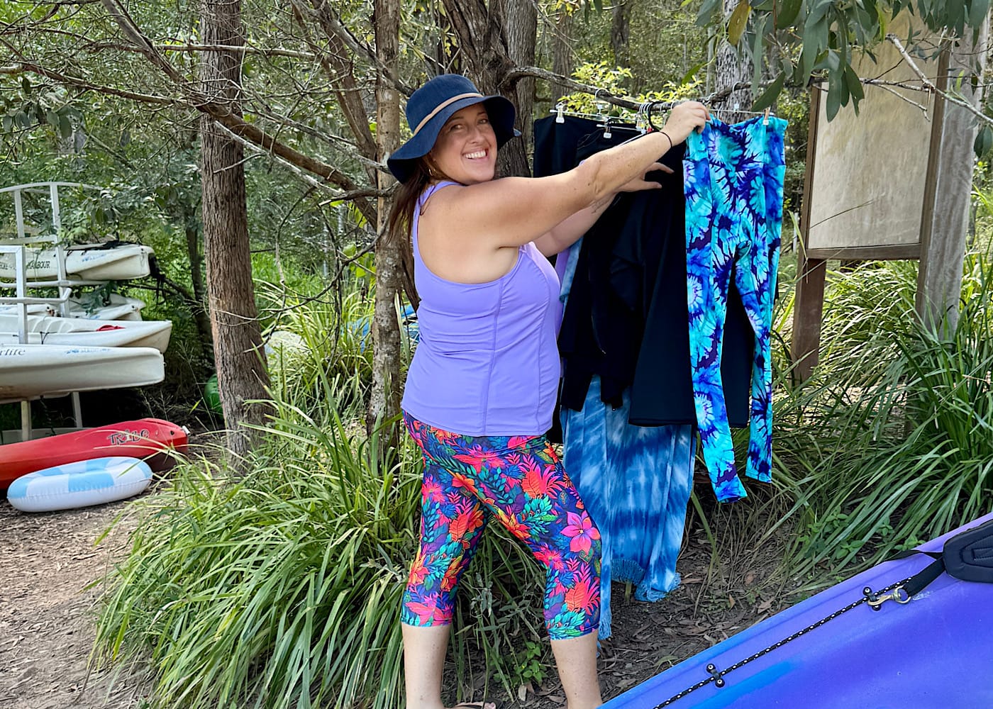 Laura Vincent looking at floral leggings hanging up, reflecting the colors of her creative work.